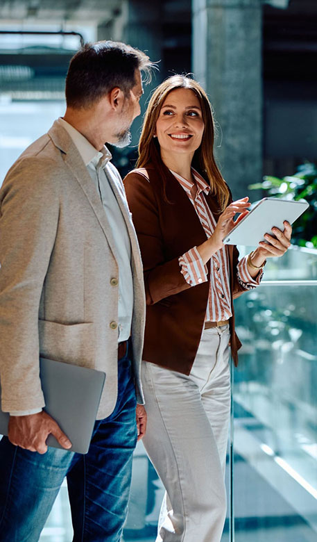 Two colleagues reviewing technology plans on a tablet in a Los Angeles office